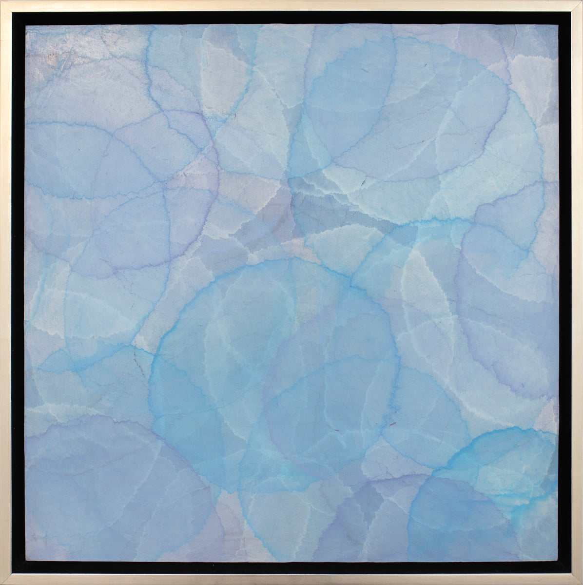 A tonal blue layered circle abstract painting in a silver floater frame.