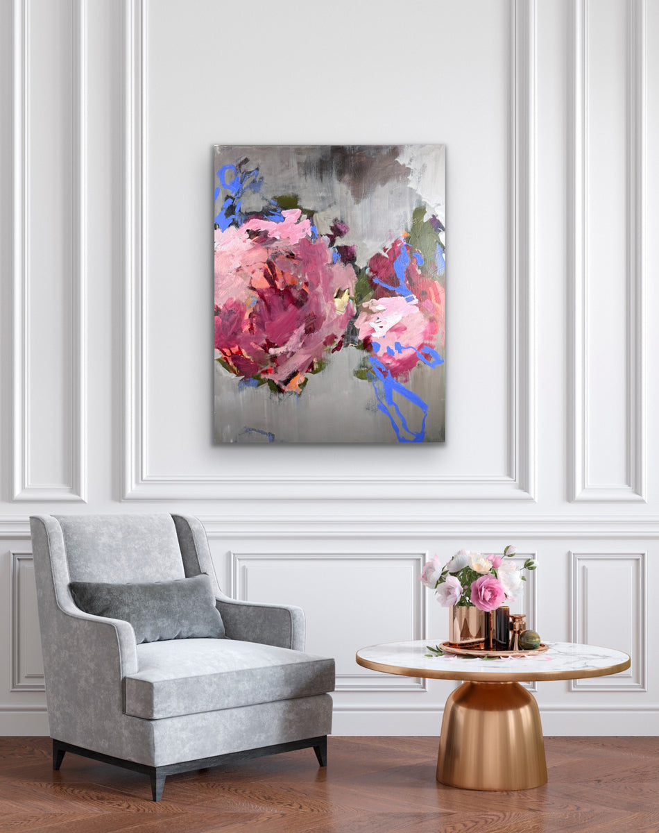 Living room with a gray armchair, small round table, and floral artwork on the wall.