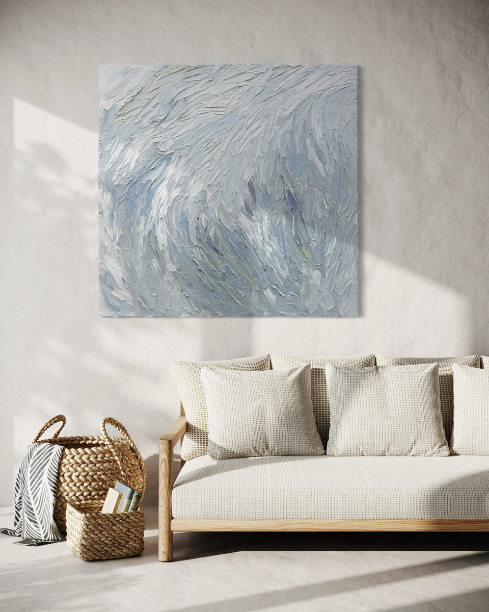 An original abstract painting by Teo Guererra on a wall above a sofa in a living room.