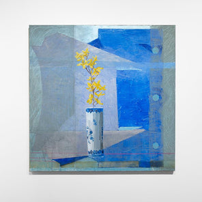 An abstracted blue painting with a vase with yellow flowers in the foreground hangs on a white wall.