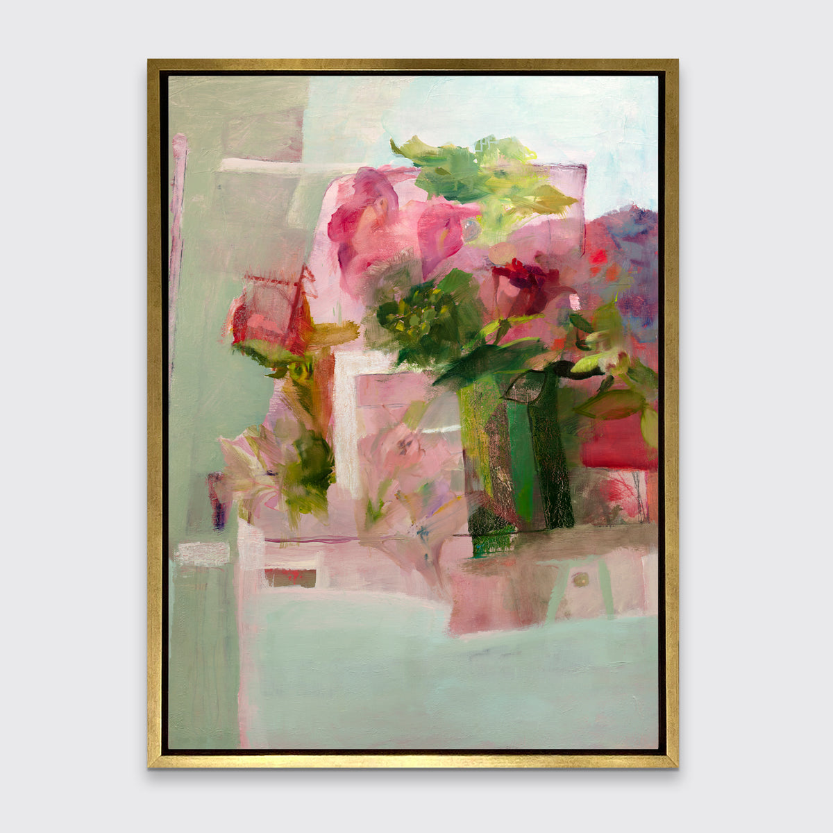 A pink, green and red abstract print in a gold floater frame hangs on a white wall.