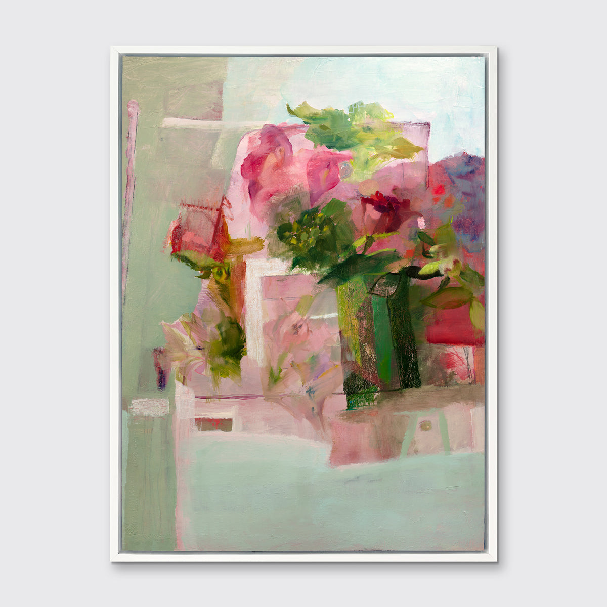 A pink, green and red abstract print in a white floater frame hangs on a white wall.