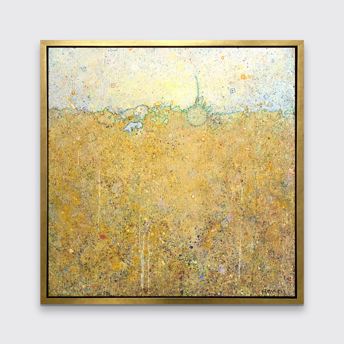 A yellow abstract landscape print in a gold floater frame hangs on a white wall.