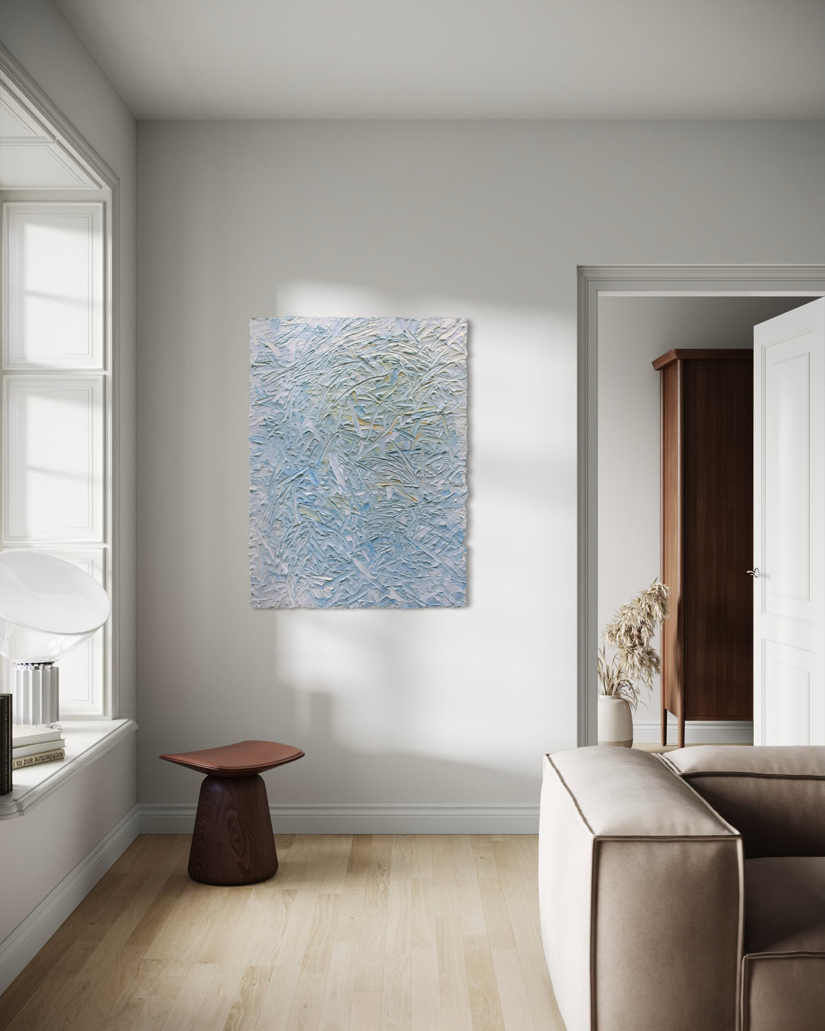 Modern living room with abstract painting on the wall, brown stool, and beige sofa.