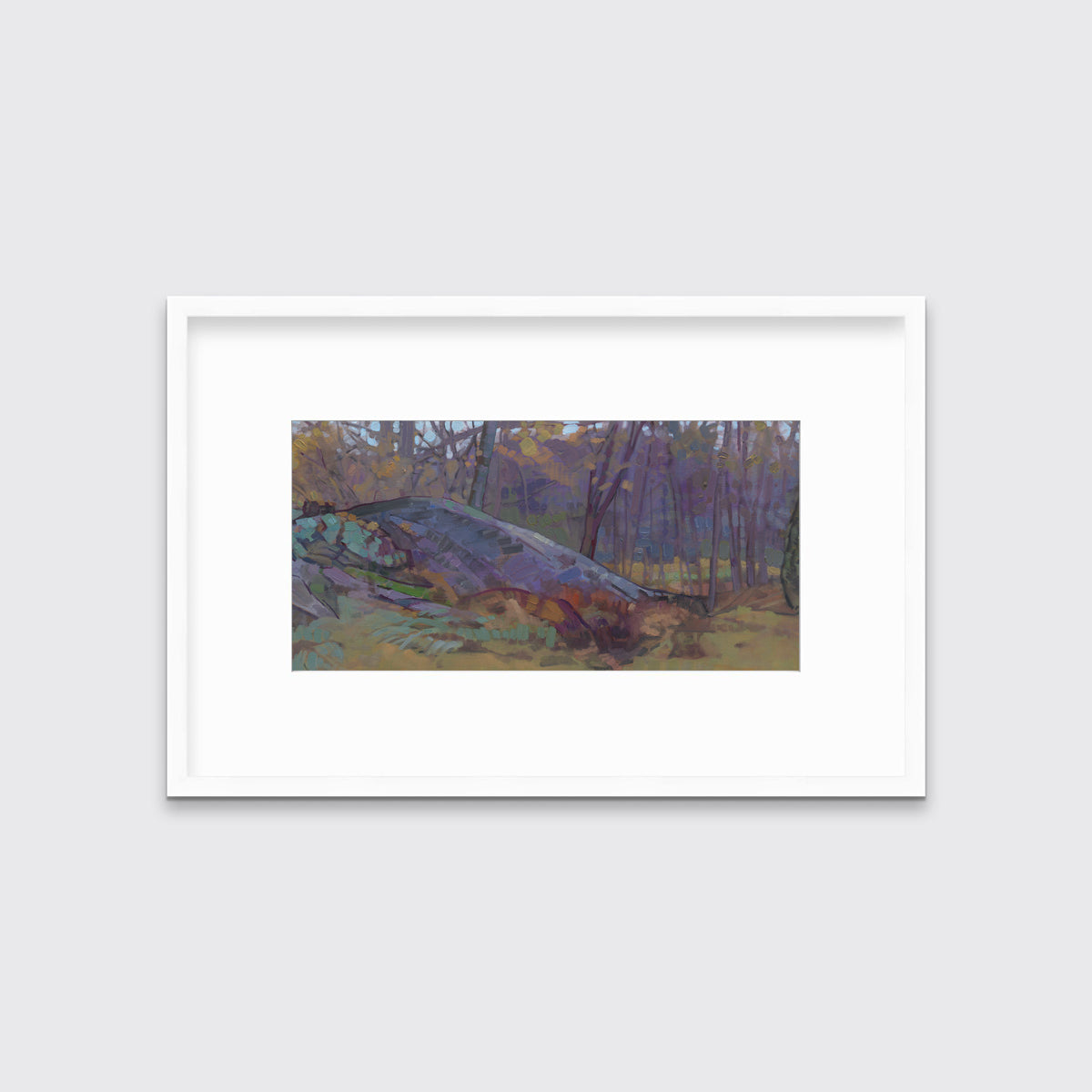 A muted multicolored abstract landscape print in a white frame with a mat hangs on a white wall.