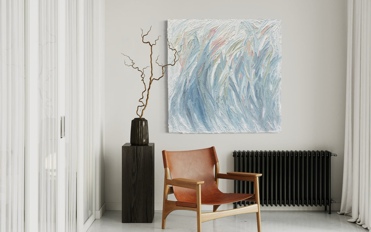 Modern interior with a brown leather chair, abstract painting, and decorative vase.