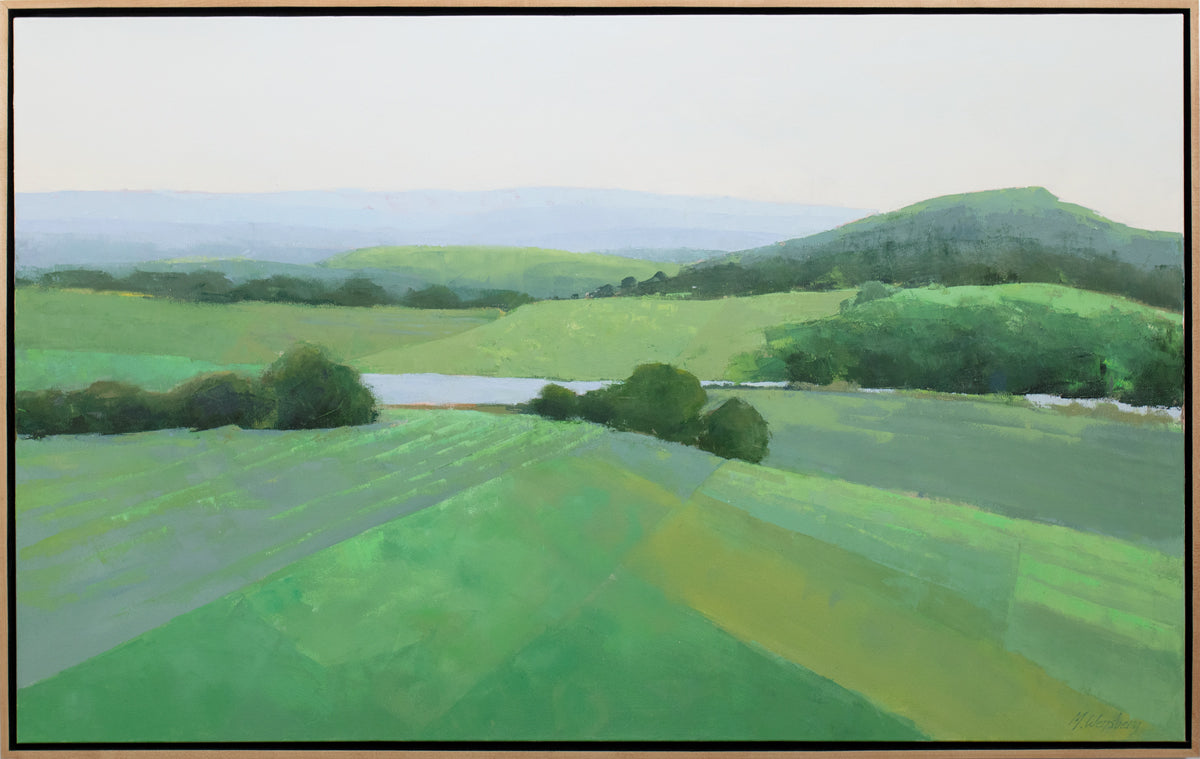 A green landscape painting framed in a light wood floater frame.