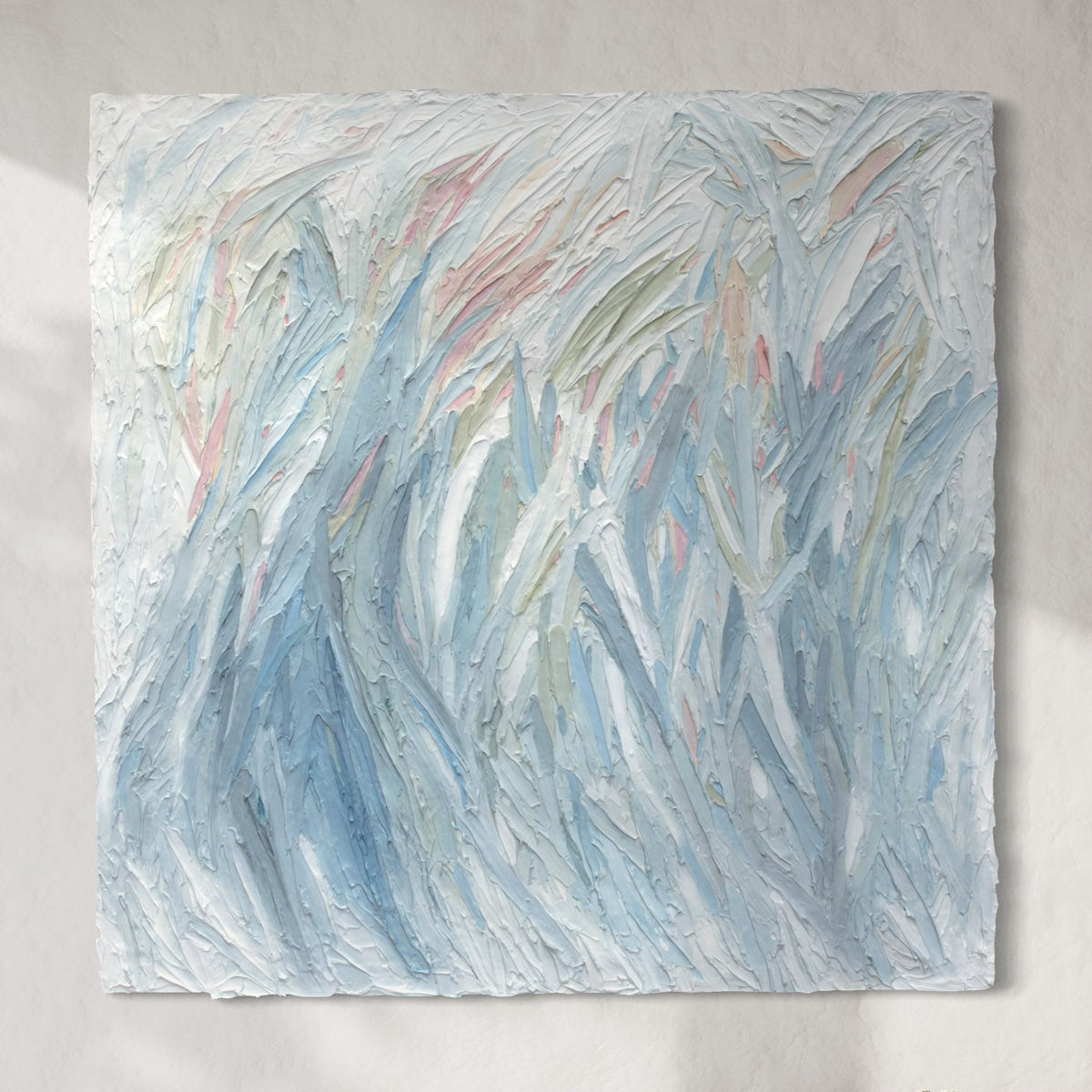 Original Abstract painting by Teo Guererra with texture in blue, green, white, and pink hanging on a sunlit wall.