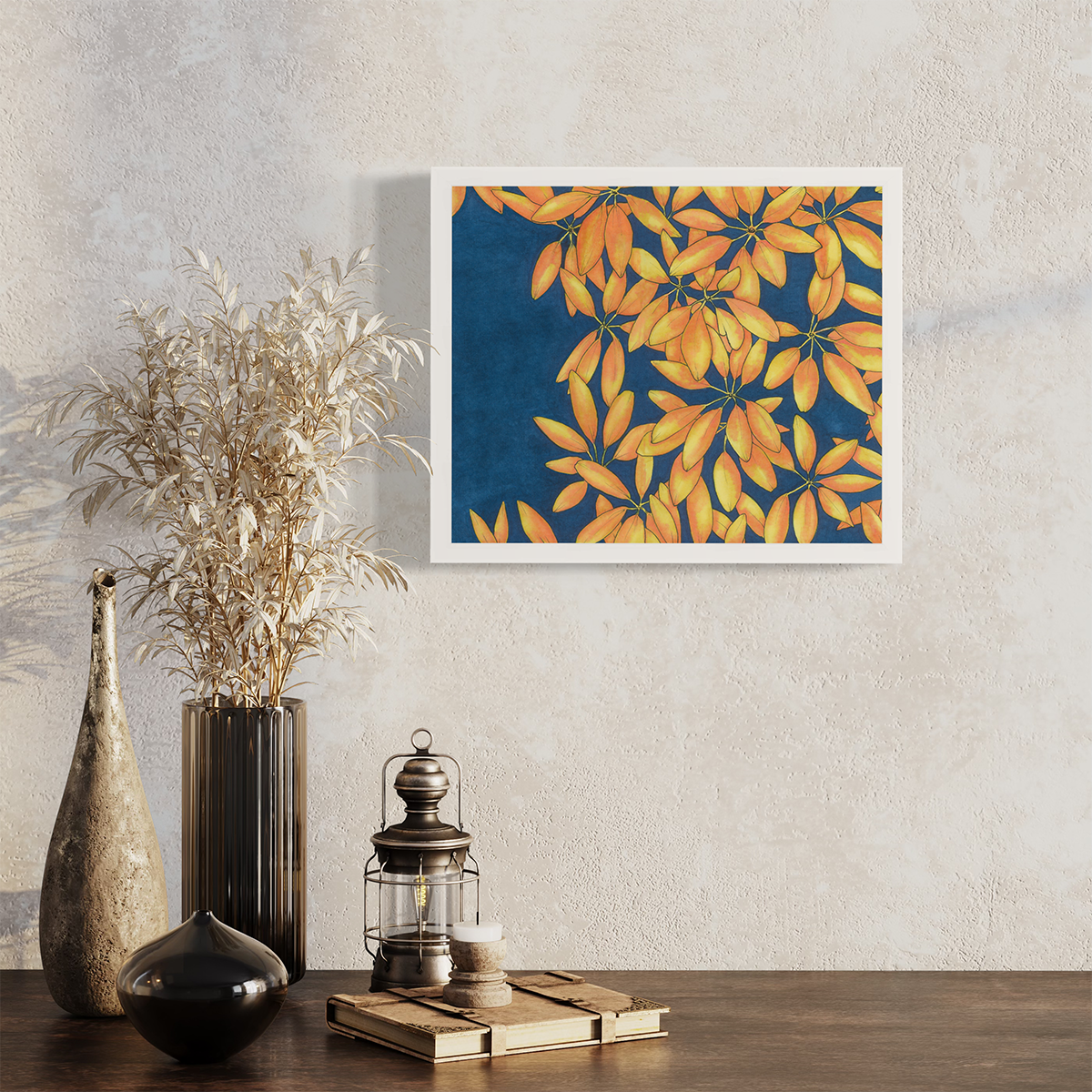A blue, yellow and orange plant print in a white frame hangs on a white wall above a wood surface with a lantern, book and various vases.
