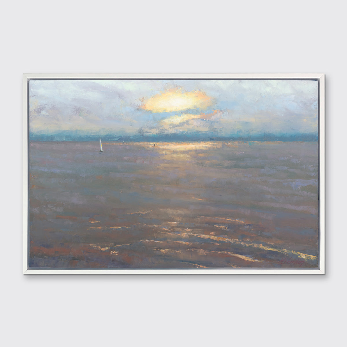 A coastal seascape print in a white floater frame hangs on a white wall.