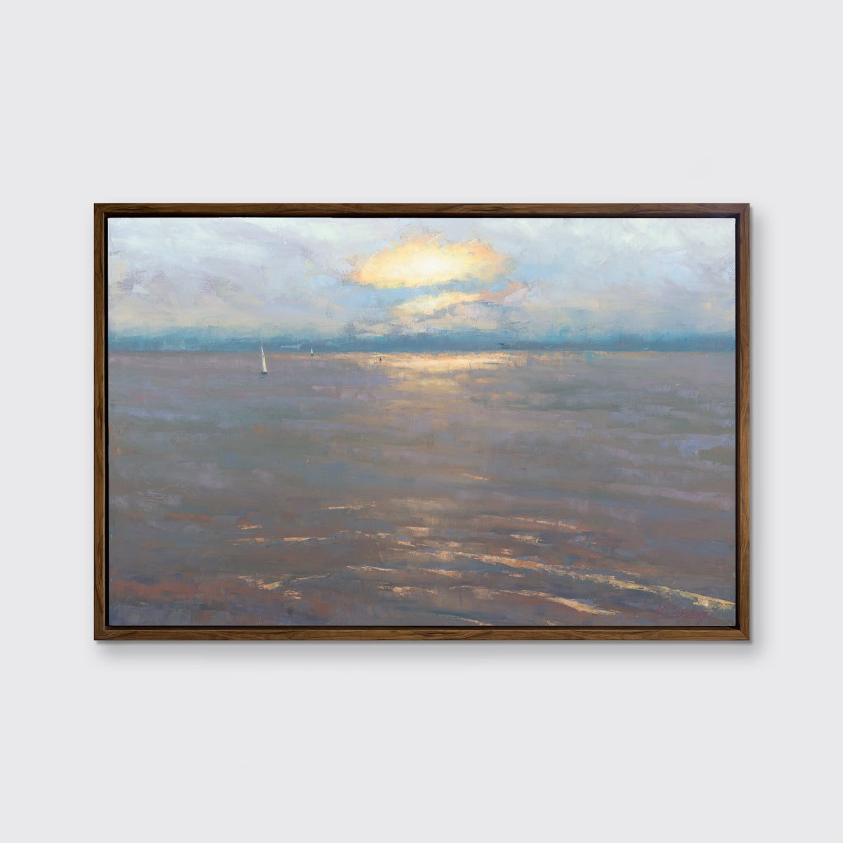 A coastal seascape print in an oak wood floater frame hangs on a white wall.