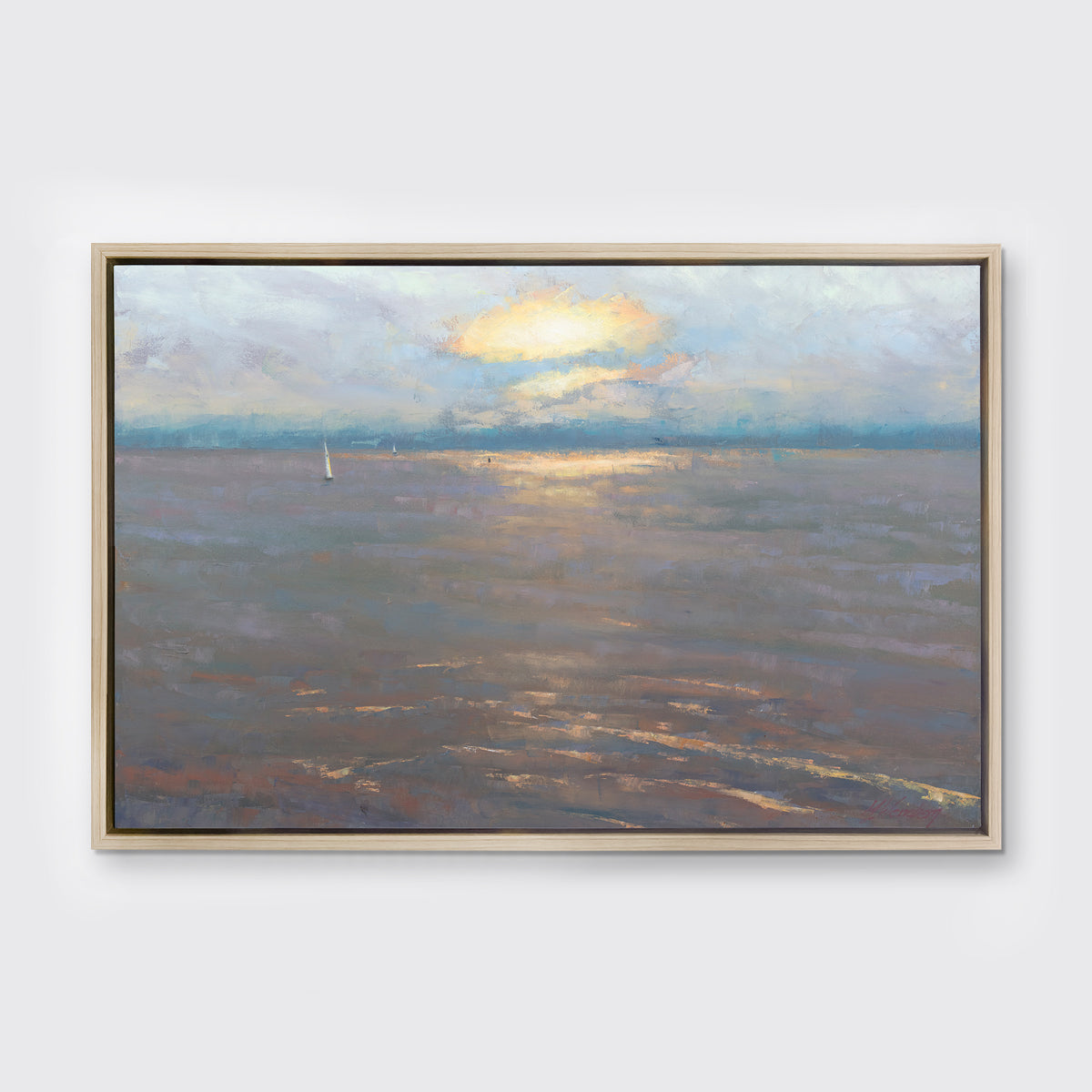 A coastal seascape print in a white oak wood floater frame hangs on a white wall.