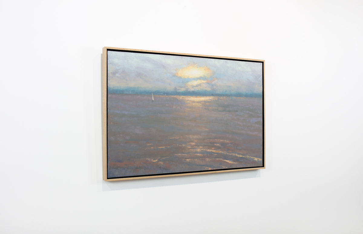 A side view of a lavender, orange, yellow and light blue coastal seascape painting by Molly Doe Wensberg hangs in a light wood floater frame on a white wall.