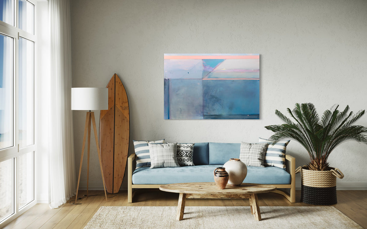 A blue and pink abstract painting hangs on a white wall over a blue sofa.