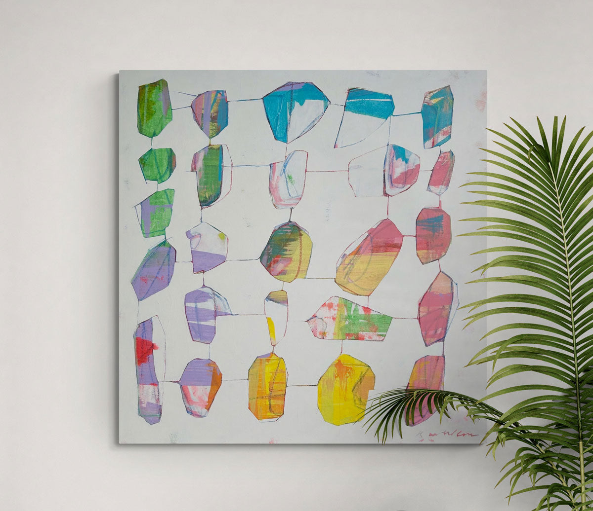 An abstract painting on a white wall next to a plant. 