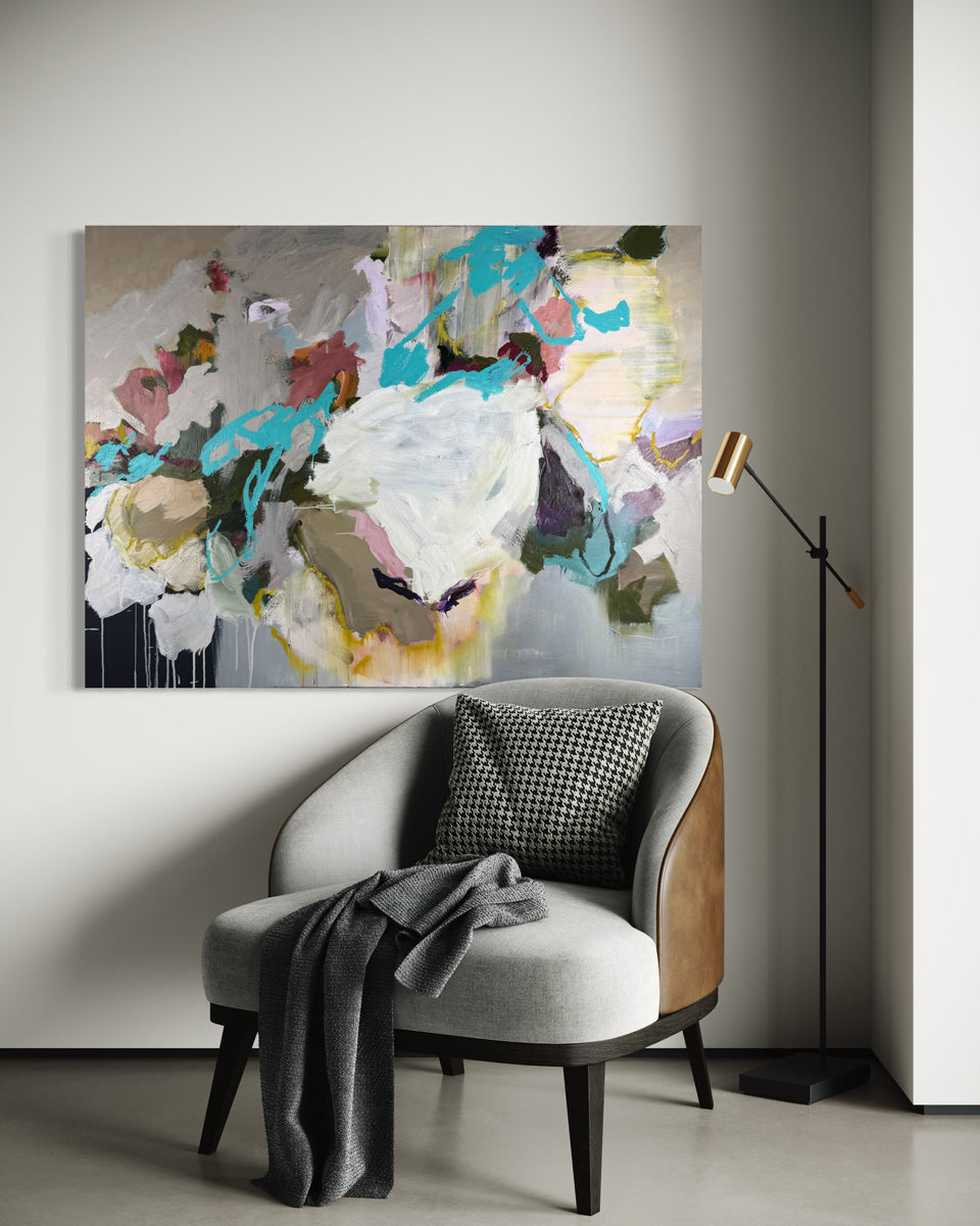 Abstract painting on a wall above a modern chair with a lamp in a room.