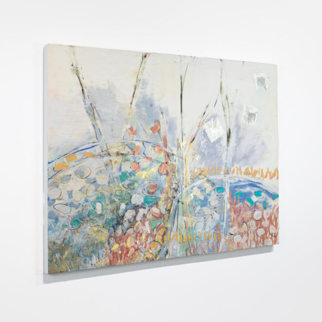 A multicolored abstract painting hangs on a white wall.