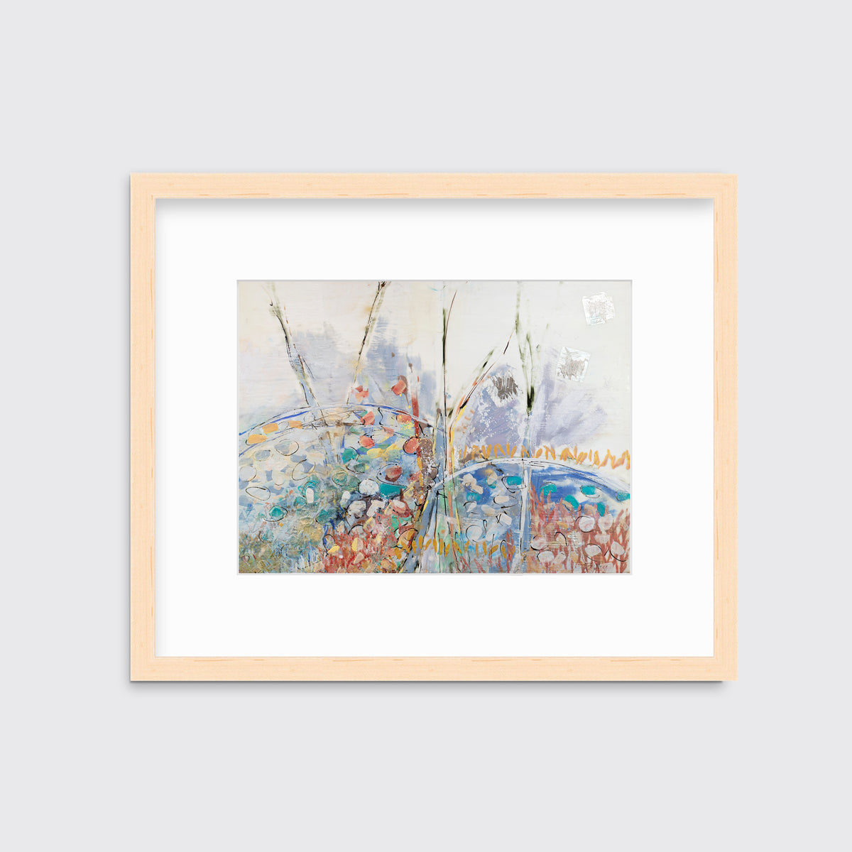 A multicolored abstract floral print in a natural wood frame with a mat hangs on a white wall.
