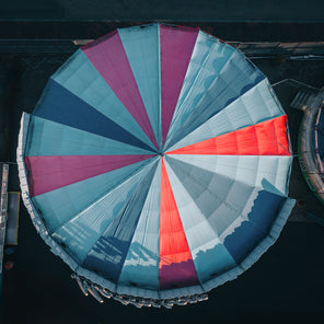 A photograph of a bird's eye view of a blue, purple and red carnival tent top. 