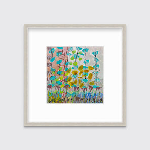 An abstract floral print in a silver frame with a mat hangs on a white wall.