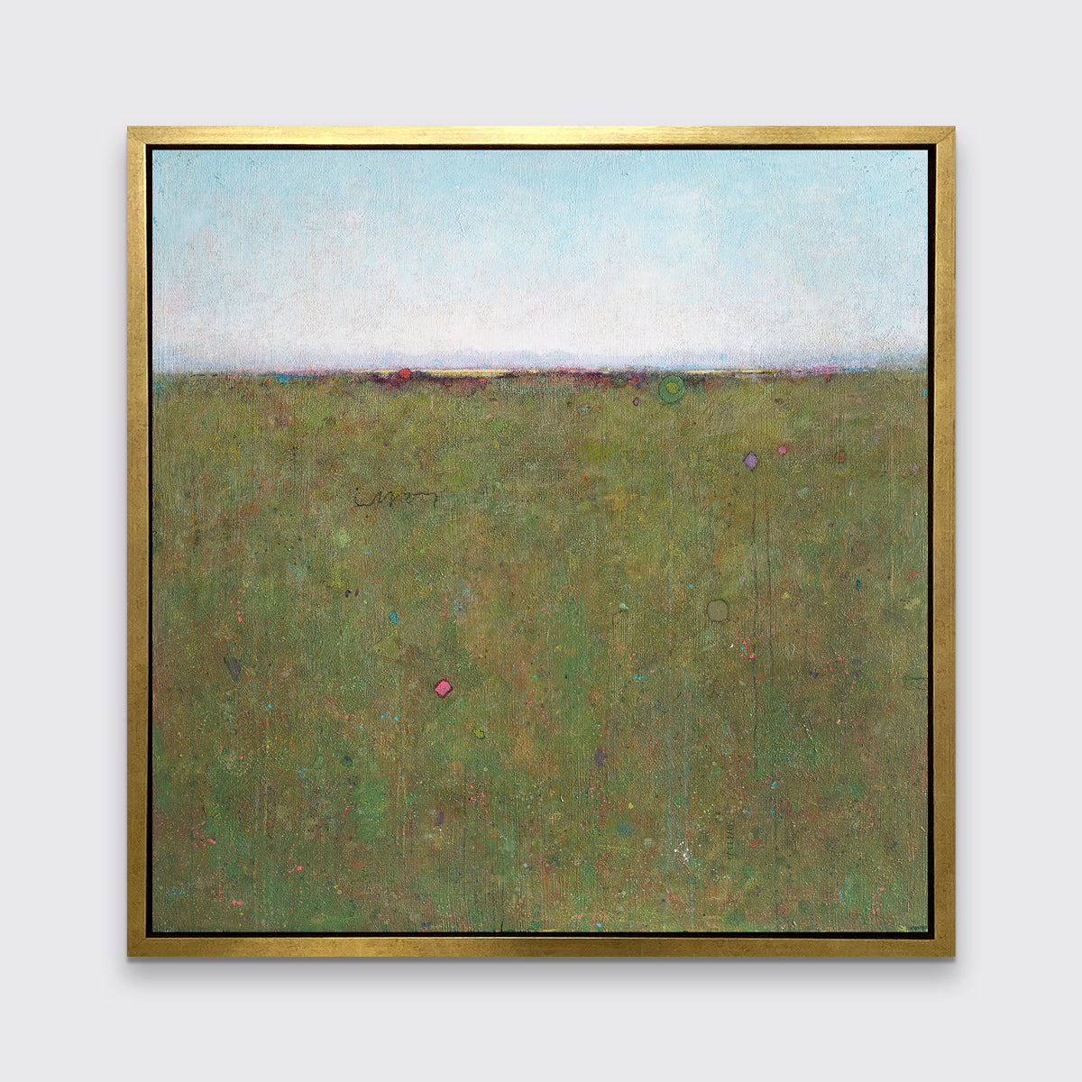 A green and blue abstract landscape print in a gold floater frame hangs on a white wall.
