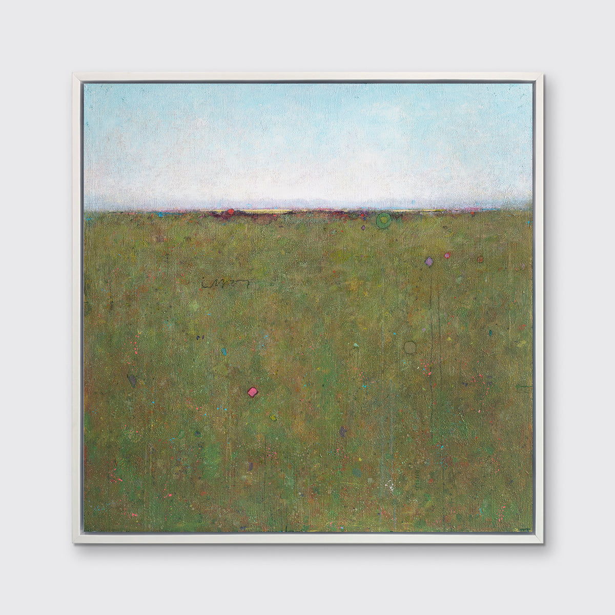 A green and blue abstract landscape print in a white floater frame hangs on a white wall.