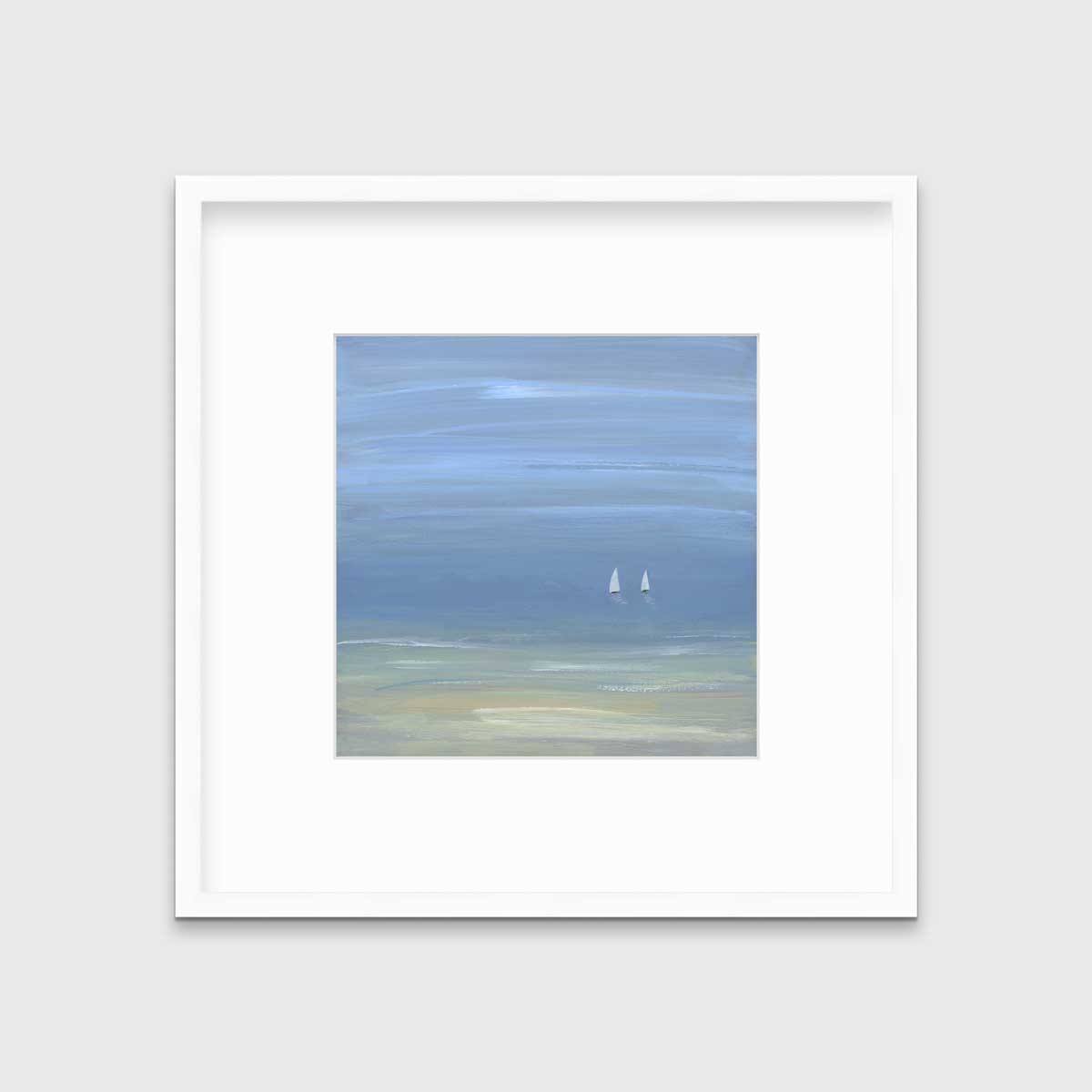 A blue, beige and white abstract seascape print with two small sailboats in a white frame with a mat hangs on a white wall.