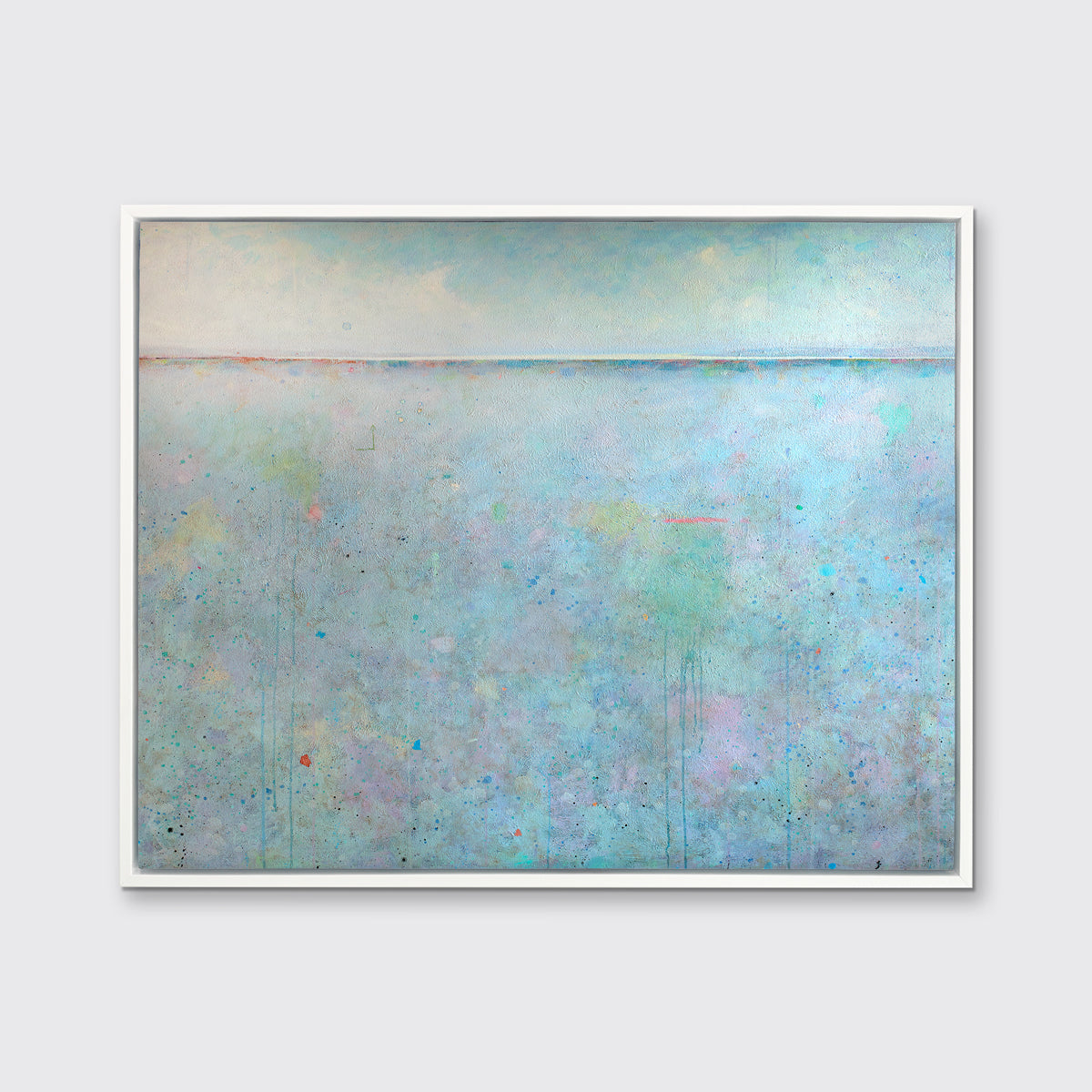 A blue abstract landscape print in a white floater frame hangs on a white wall.