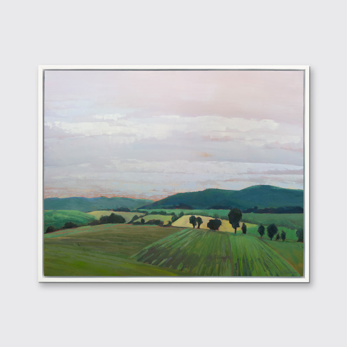 A landscape print in a white floater frame hangs on a white wall.