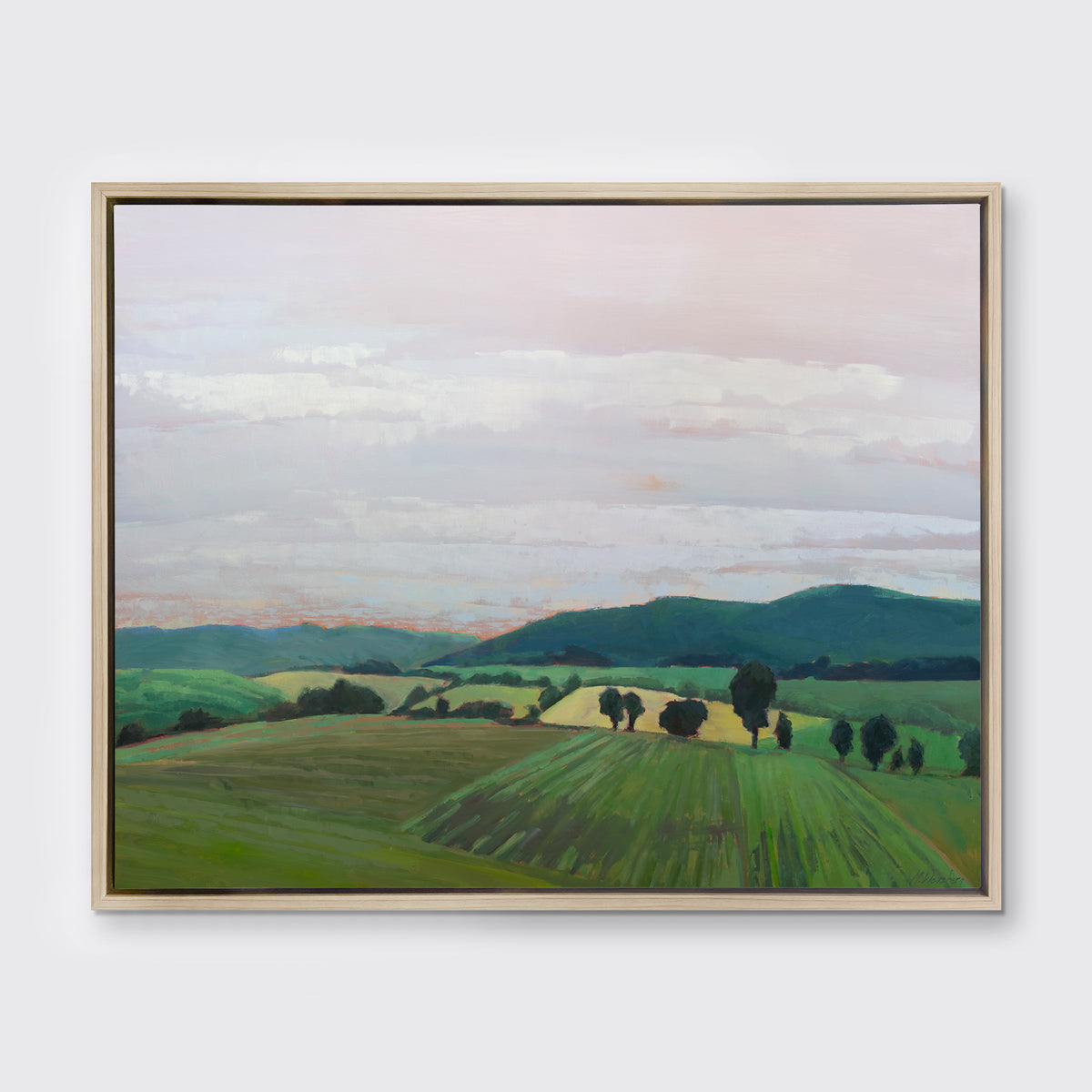 A landscape print in a white oak wood floater frame hangs on a white wall.
