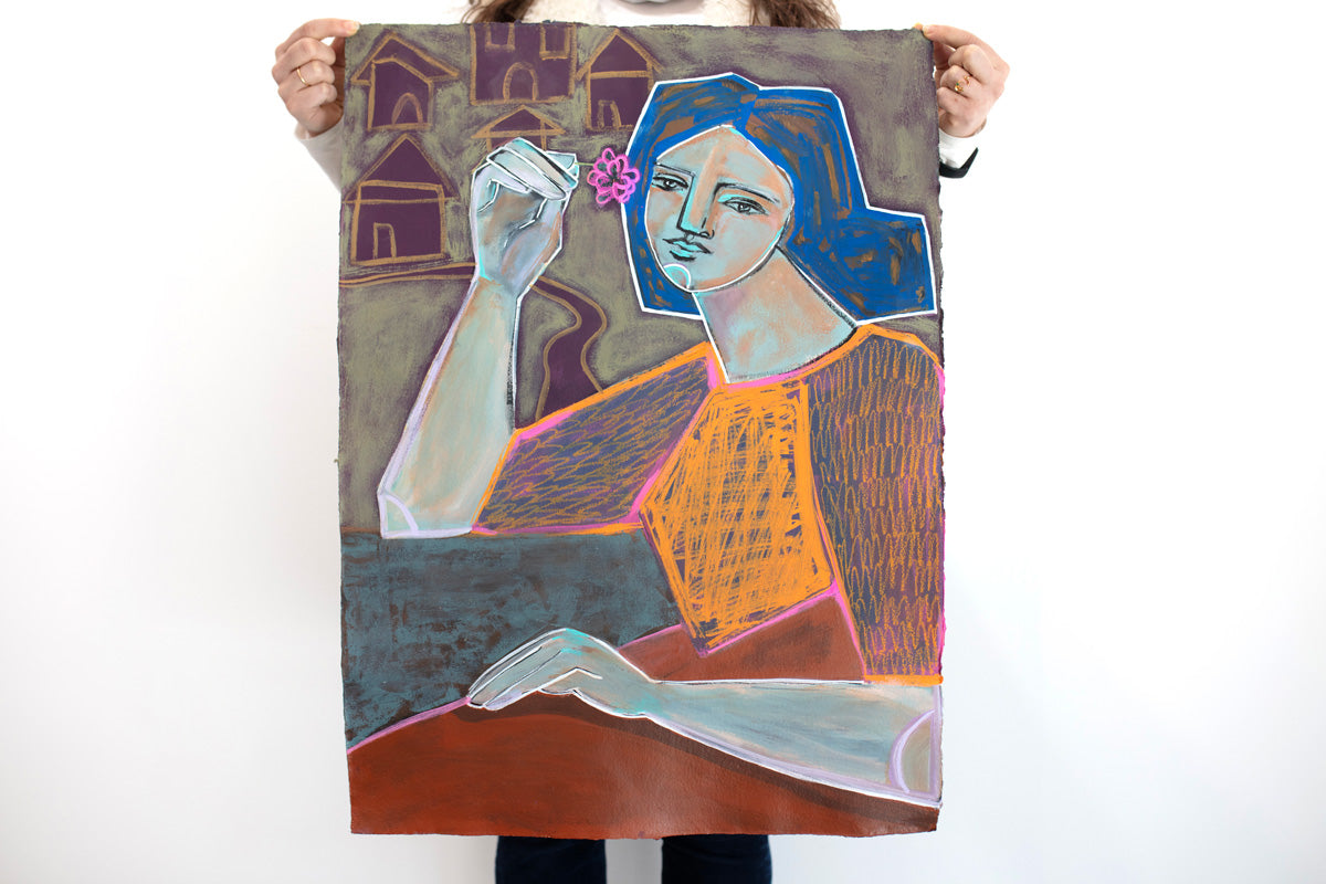 A woman stands in front of a white wall holding a blue, orange, yellow and deep violet abstracted painting of a woman holding a pink flower.