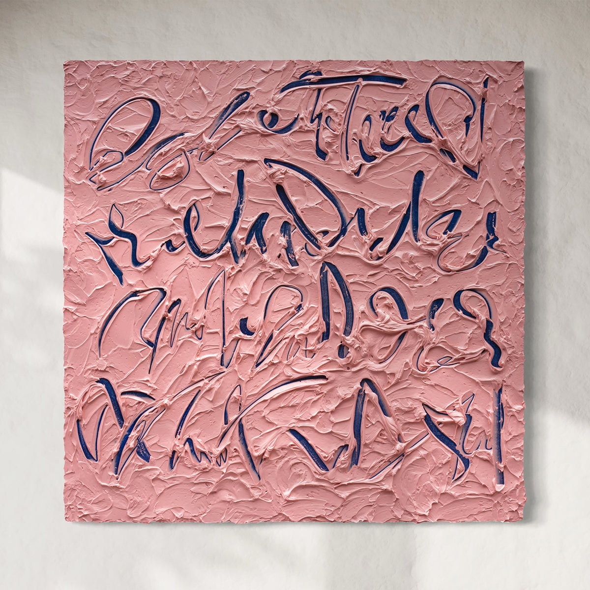 Original text based painting featuring abstract textured brushstrokes in dusty pink and dark navy blue, displayed against a light neutral wall.