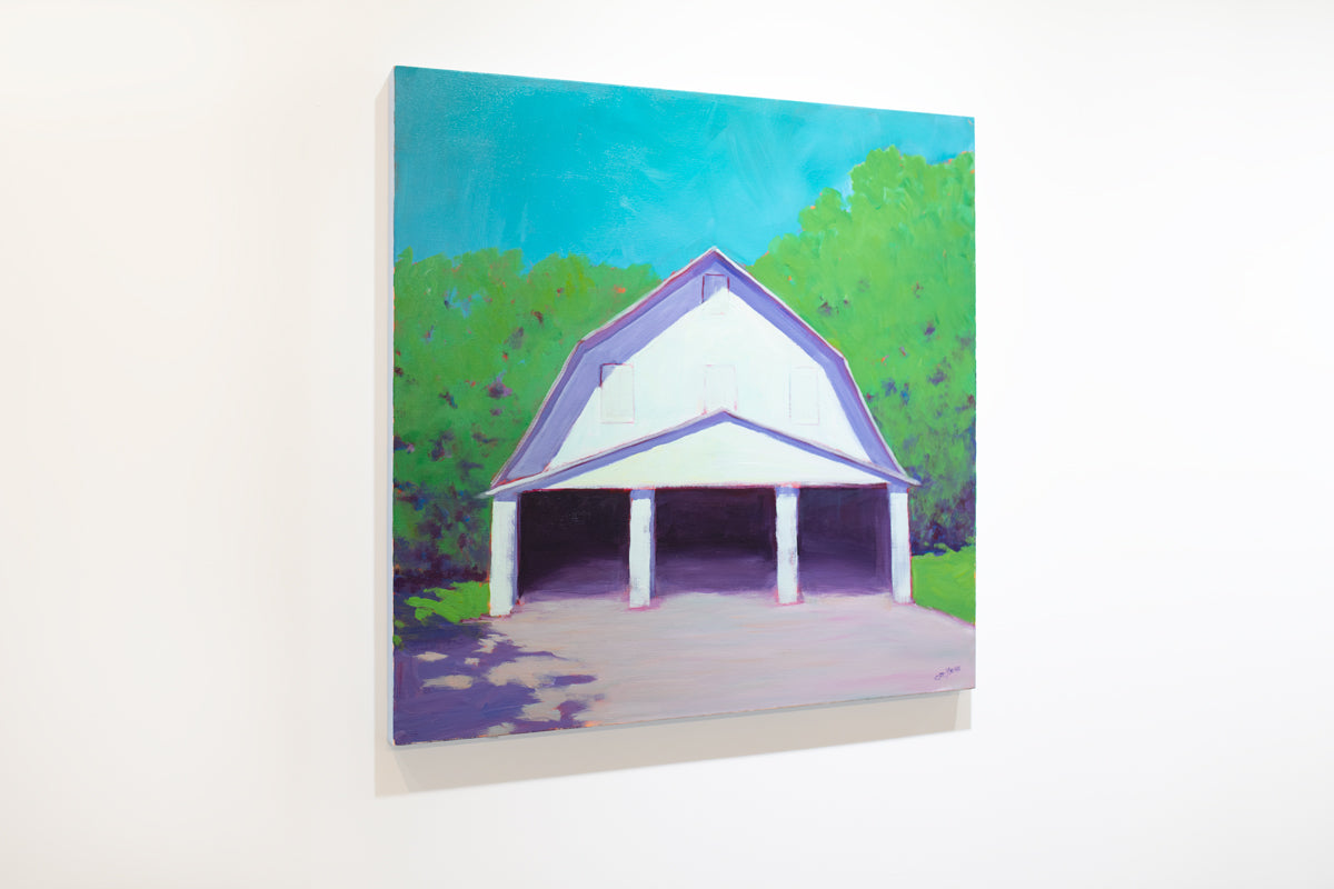 A left side view of a landscape painting of a white barn with three open doors, lavender shadows, blue sky and surrounded by greenery by Carol Young.