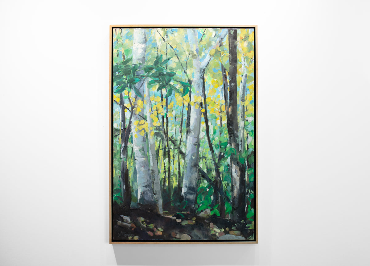 A framed green painting of a forest hangs on a white wall. 