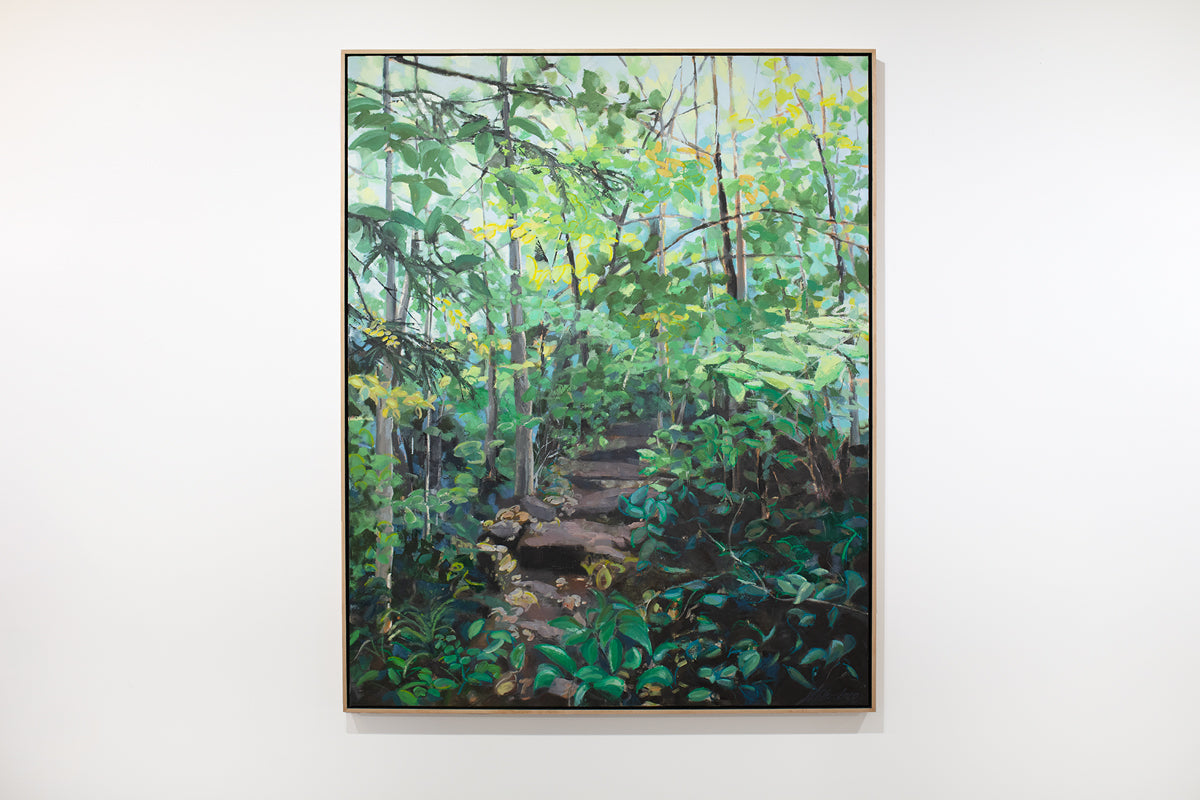 A large framed green painting of a forest hangs on a white wall.