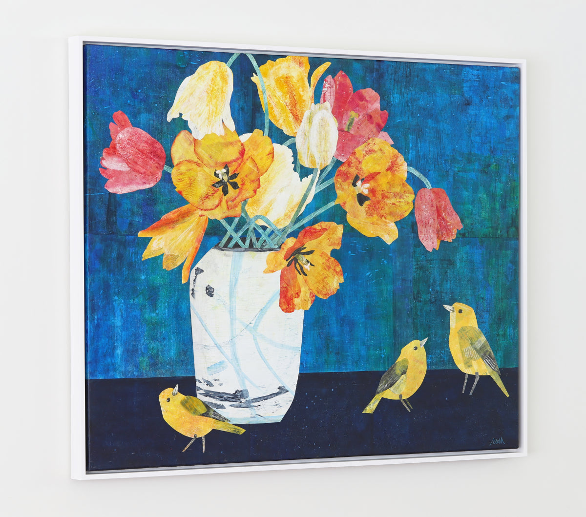A framed square collage featuring a white vase filled with yellow, orange, and pink flowers against a textured blue background, with three small yellow birds on a dark surface below.