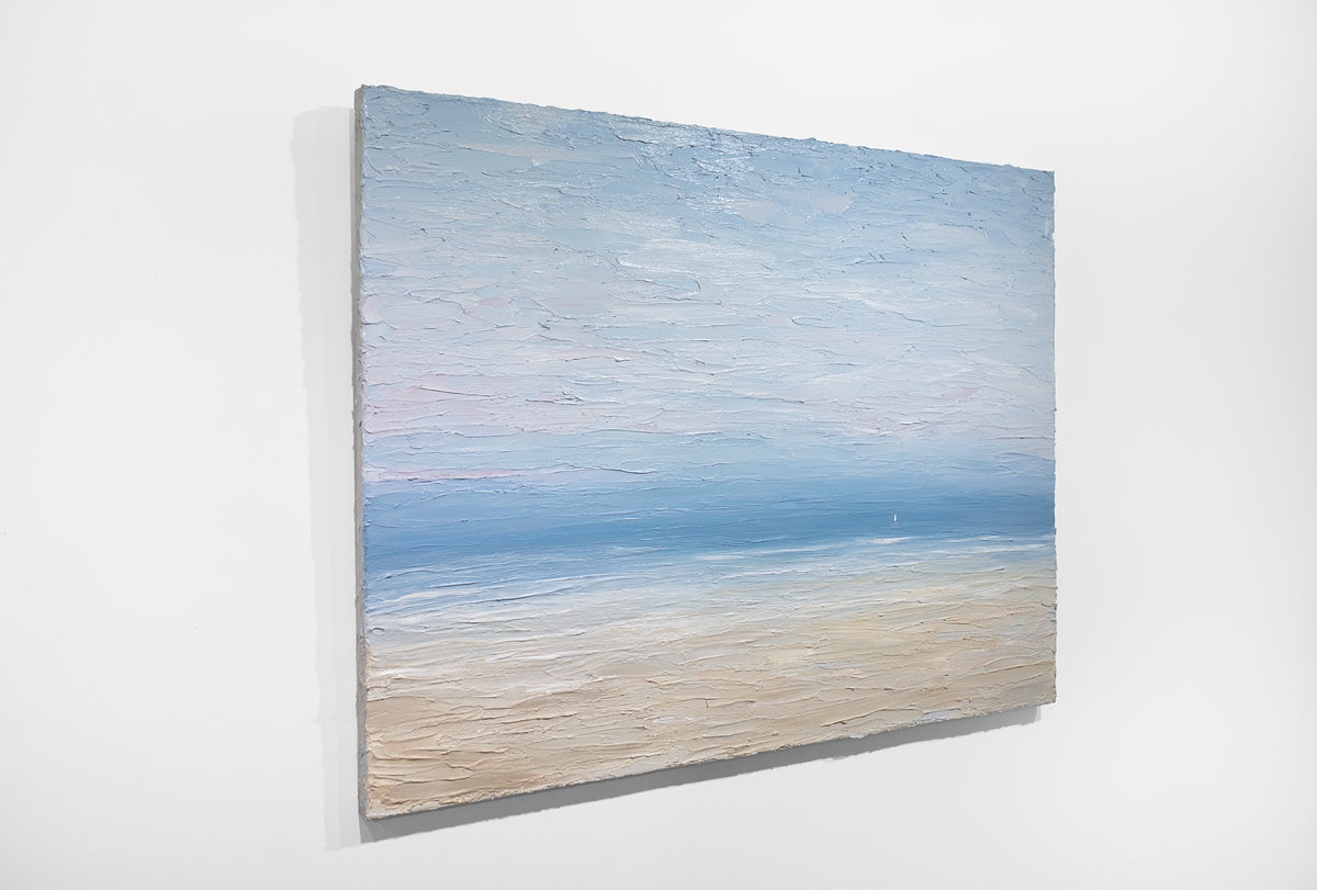 An abstracted coastal painting hangs on a white wall.