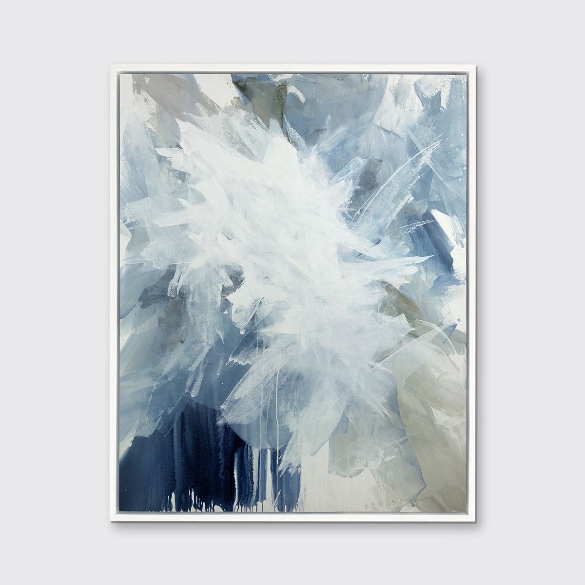 A white, blue and grey abstract print in a white floater frame hangs on a white wall.
