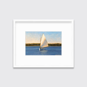 A blue and beige contemporary seascape print with a sailboat in a white frame with a mat hangs on a white wall.