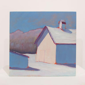 A blue, red, and white contemporary winter landscape painting stands upright on a white surface in front of a white wall. 