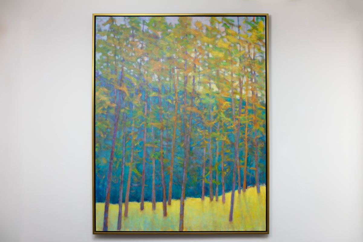Framed painting of trees with a colorful landscape on a white wall