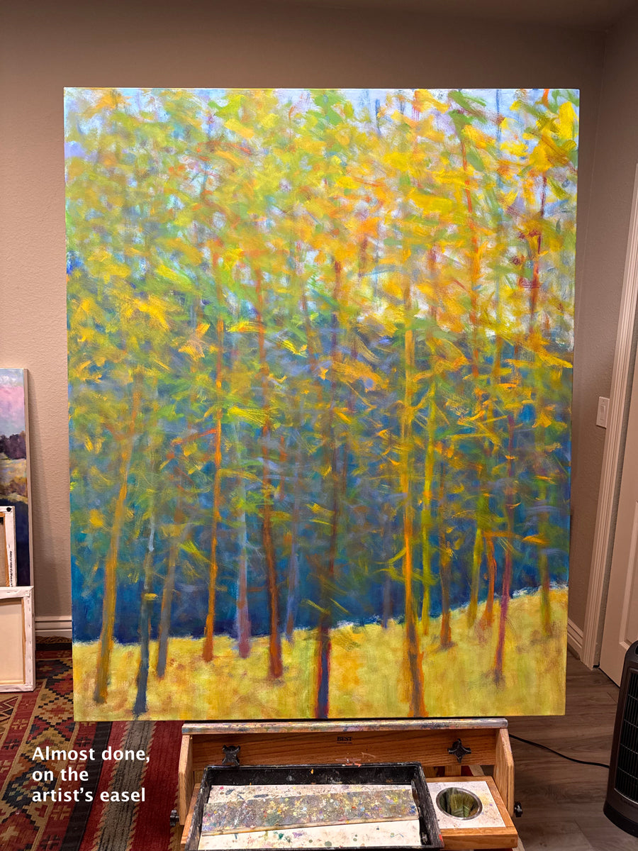 Painting of a forest scene with trees in yellow and blue on an artist's easel.