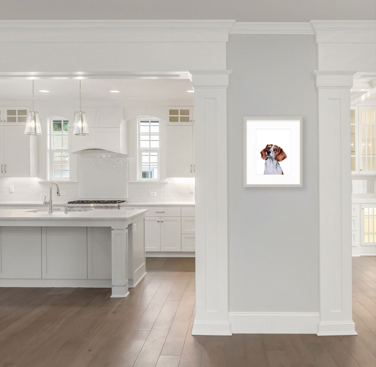 An illustration of a beagle dog framed in a silver frame hangs on a light grey wall next to a modern kitchen. 
