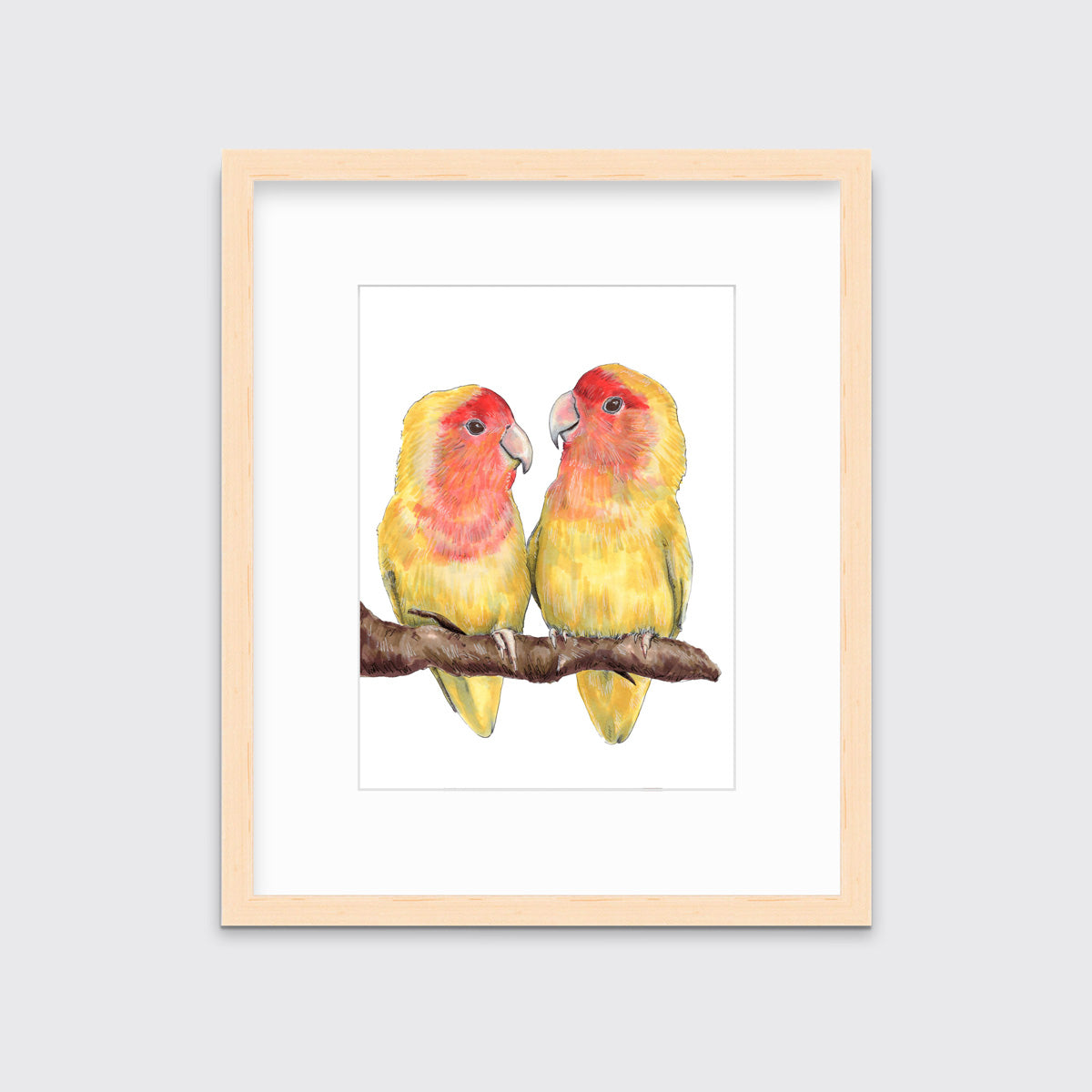 An illustration of two yellow birds sitting on a branch framed in a natural wood frame hangs on a white wall. 