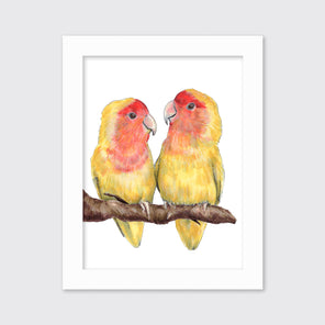 An illustration of two yellow birds on a branch framed in a white frame hangs on a light grey wall. 