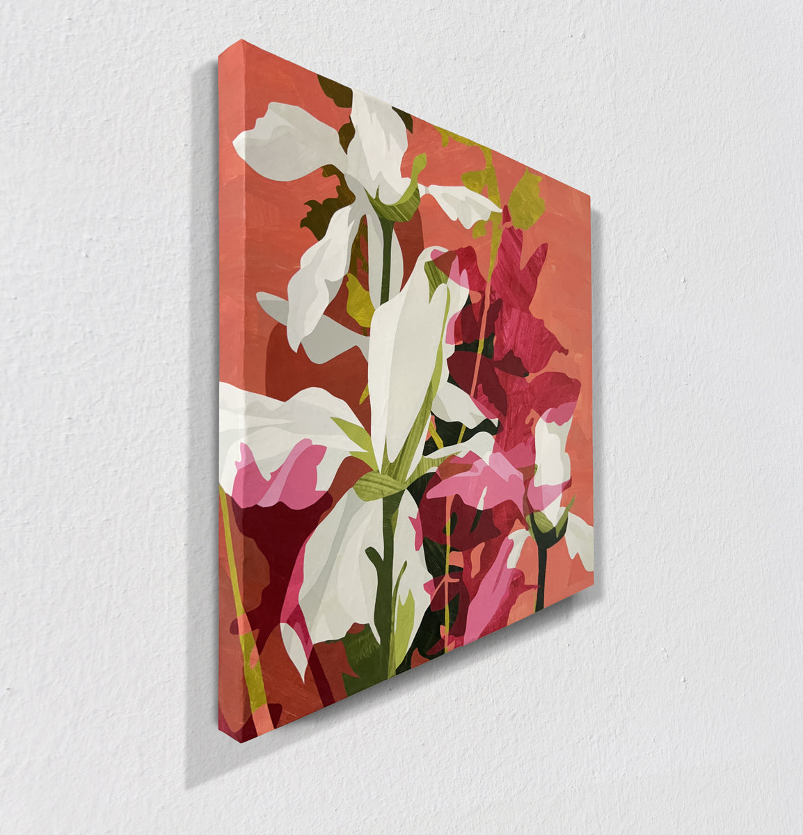 Floral artwork with red, white, and pink flowers on a textured red background hanging on a white wall, side view.