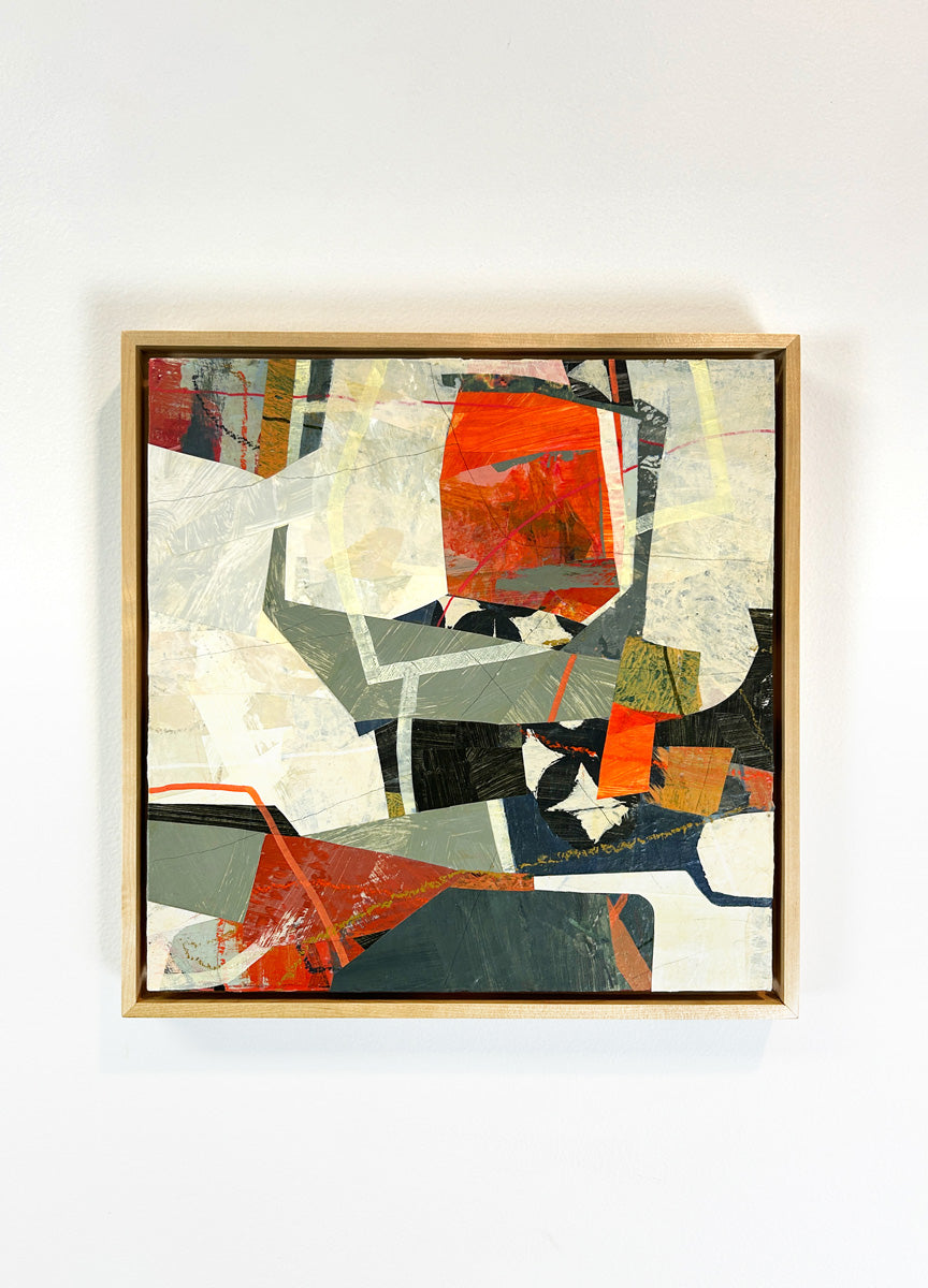 A framed abstract collage artwork featuring geometric shapes in shades of red, beige, and green, with a white background hanging on a white wall.