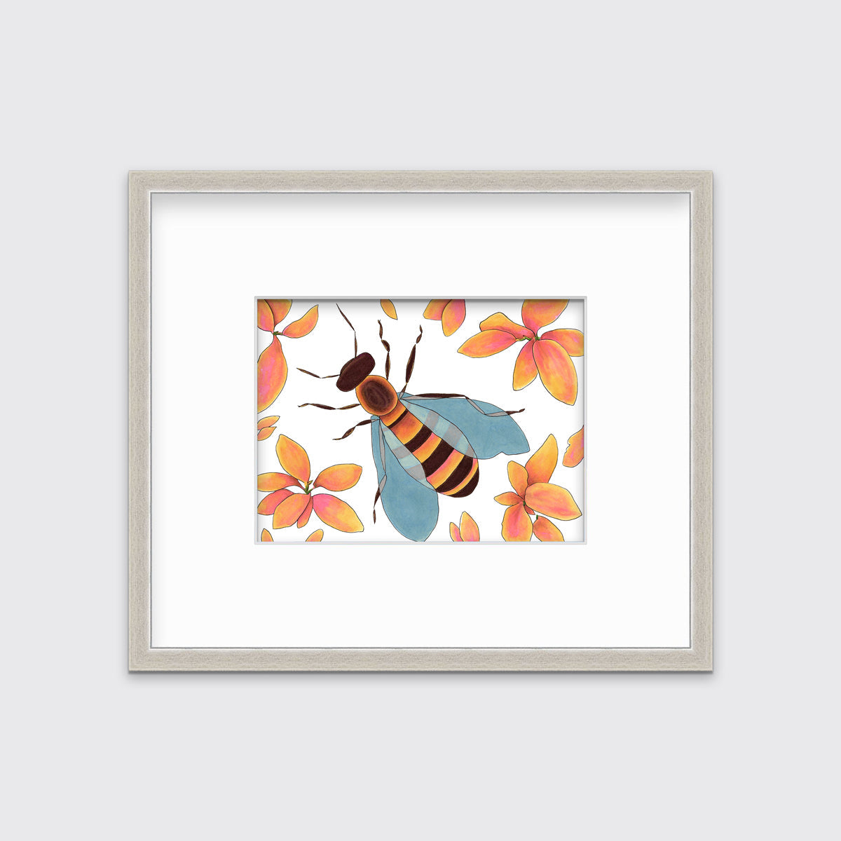 A bee surrounded by orange and pink flowers in a silver frame with a mat hangs on a white wall 
