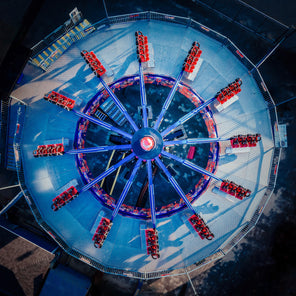 A photograph of a bird's eye view of a blue and red carnival ride. 