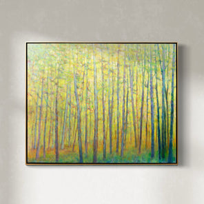 A yellow abstracted forest trees painting framed in a thin gold floater frame hangs on a white wall. 